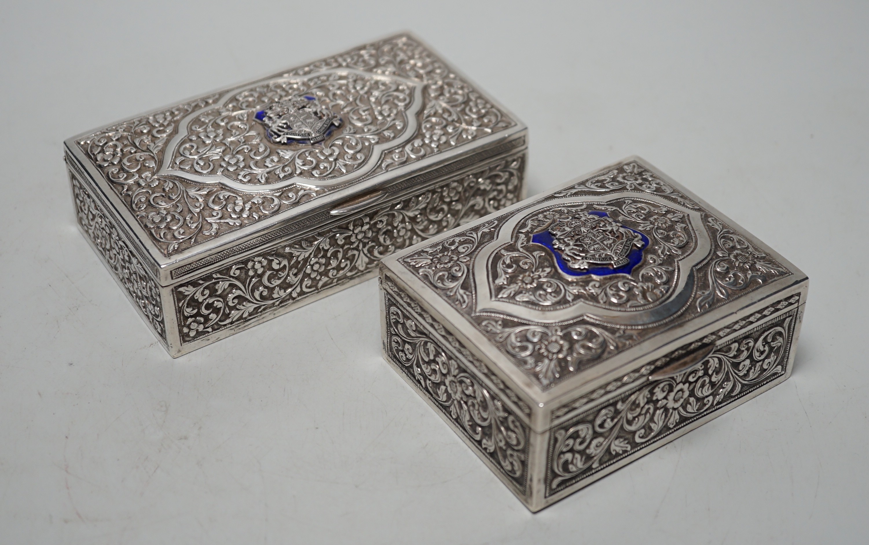Two early 20th century Indian embossed white metal rectangular boxes, both applied with the enamelled rest of the Bhuj Kutch Gujarat, largest 14.2cm
